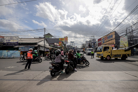 Aktivitas sukarelawan pengatur lalu lintas (supeltas) di persimpangan Jalan Raya Sawangan dan Jalan Pramuka, Kelurahan Mampang, Kecamatan Pancoran Mas, Depok, Jumat (9/1/2026). Foto: Jamal Ramadhan/kumparan