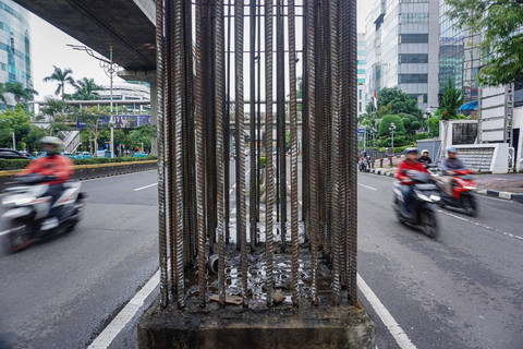 Pengendara sepeda motor melintas di samping tiang monorel yang mangkrak di Jalan Rasuna Said, Jakarta, Jumat (9/1/2026). Foto: Ika Maryani/ANTARA FOTO