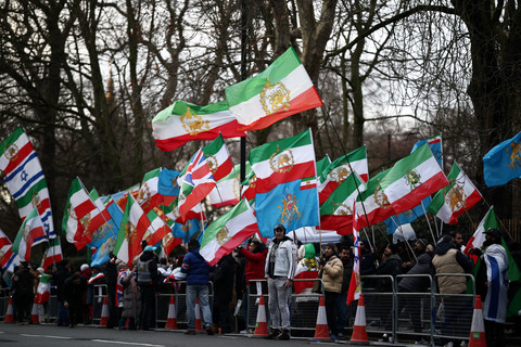 Demonstran anti-rezim Iran mengibarkan bendera Iran sebelum revolusi 1979 dengan lambang Singa dan Matahari di luar Kedutaan Besar Iran, London, Jumat (9/1/2026). Foto: HENRY NICHOLLS / AFP