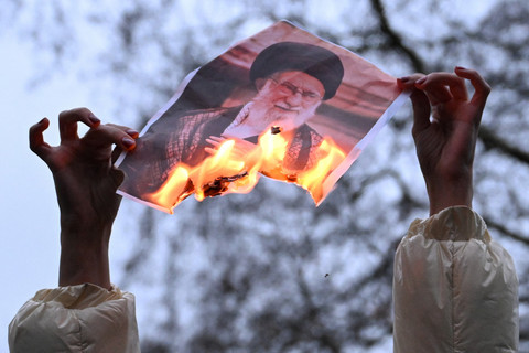 Seorang demonstran memegang foto Pemimpin Tertinggi Iran Ayatollah Ali Khamenei yang terbakar, selama protes dukungan terhadap rakyat Iran di luar Downing Street, di London, Inggris, 11 Januari 2026. Foto: REUTERS/Chris J Ratcliffe