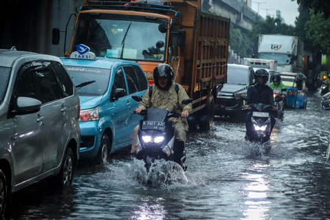 Sejumlah pengendara sepeda motormenerobos banjir di kawasan Sunter, Jakarta Utara, akibat genangan air yang menutup sebagian badan jalan, Senin (12/1/2026) siang.  Foto: Iqbal Firdaus/kumparan