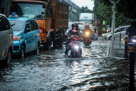 Sejumlah pengendara sepeda motor menerobos banjir di kawasan Sunter, Jakarta Utara, akibat genangan air yang menutup sebagian badan jalan, Senin (12/1/2026) siang.  Foto: Iqbal Firdaus/kumparan