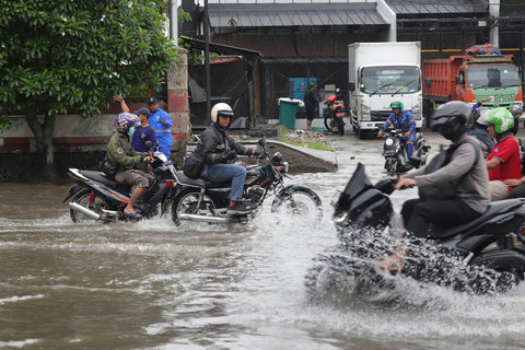 Pengendara melintasi genangan air setinggi sekitar 20-30 sentimeter di Jalan Gunung Sahari Raya, Pademangan, tepatnya di depan WTC Mangga Dua, Jakarta Utara, Selasa (13/1/2026). Foto: Jamal Ramadhan/kumparan