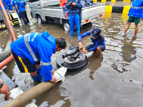 Petugas Suku Dinas Sumber Daya Air DKI Jakarta menangani genangan air di Jalan Gunung Sahari, Jakarta Utara, Selasa (13/1/2026). Foto: Jeni Ritanti/kumparan