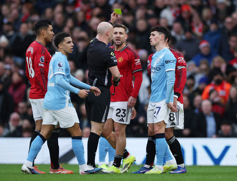 Luke Shaw dari Manchester United diberi kartu kuning oleh wasit Anthony Taylor pada pertandingan Liga Inggris antara Manchester United vs Manchester City di Old Trafford, Manchester, Sabtu (17/1/2026). Foto: Phil Noble/REUTERS