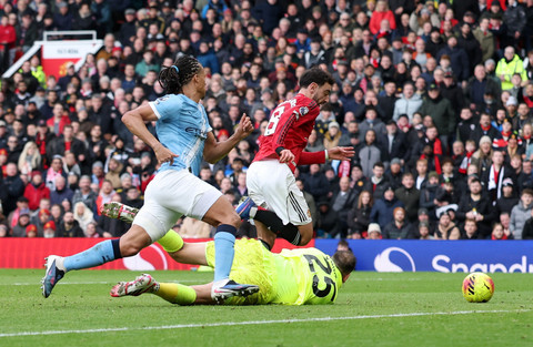 Bruno Fernandes dari Manchester United beraksi dengan Gianluigi Donnarumma dari Manchester City sebelum mencetak gol yang kemudian dianulir pada Liga Inggris antara Manchester United vs Manchester City di Old Trafford, Manchester, Sabtu (17/1/2026). Foto: Phil Noble/REUTERS