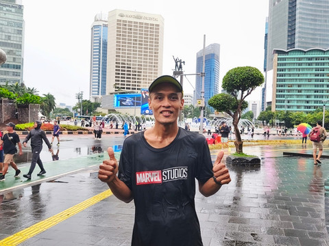 Mulyadi (43), warga yang tetap berlari meskipun hujan di CFD Thamrin-Sudirman, Jakarta Pusat, Minggu (18/1/2026). Foto: Jeni Ritanti/kumparan