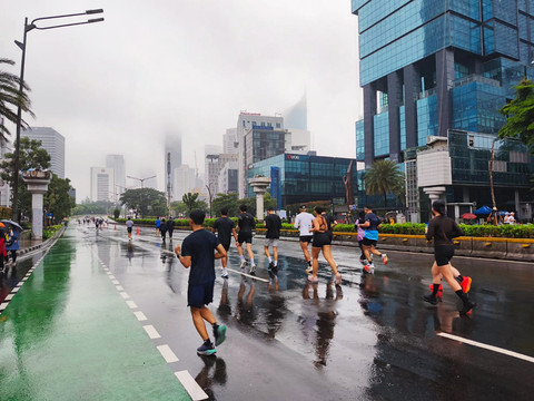 Warga tetap antusias lari pagi meskipun diguyur hujan pada saat CFD Thamrin-Sudirman, Jakarta Pusat, Minggu pagi (18/1/2026). Foto: Jeni Ritanti/kumparan