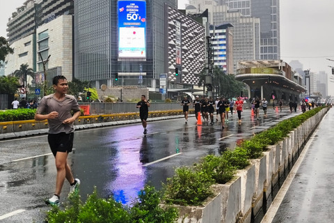 Warga tetap antusias lari pagi meskipun diguyur hujan pada saat CFD Thamrin-Sudirman, Jakarta Pusat, Minggu pagi (18/1/2026). Foto: Jeni Ritanti/kumparan