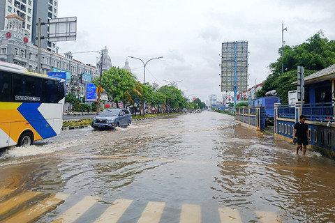 Kendaraan bermotor dan warga melintasi banjir yang terjadi di depan MOI, Jalan Boulevard Barat Raya, Jakarta Utara, Minggu (18/1/2026). Foto: Ryan Iqbal/kumparan