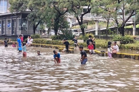 Anak-anak dan warga sekitar bermain di kawasan banjir yang menggenangi Jalan Gunung Sahari, Jakarta Utara, Minggu (18/1/2026). Foto: Jeni Ritanti/kumparan