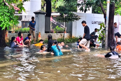 Anak-anak bermain di genangan banjir sekitar kawasan Gunung Sahari tepatnya di jalan Budi Mulia Ampera 7, Jakarta Utara, Minggu (18/1/2026). Foto: Jeni Ritanti/kumparan