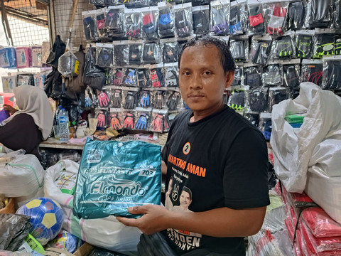 Roni (32), salah satu pedagang jas hujan dan payung di Pasar Asemka, Jakarta Utara, Jumat (23/1). Foto: Ryan Iqbal/kumparan