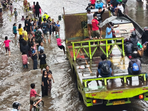 Anak-anak bermain air di area banjir yang bersebelahan dengan lalu lalang kendaraan di Jalan Daan Mogot, Jakarta Barat, Jumat (23/1). Foto: Jeni Ritanti/kumparan