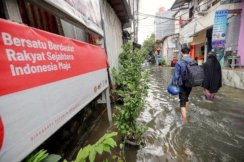 Warga berjalan melintasi banjir yang masih menggenangi permukiman warga RW 02, Kelurahan Rawa Buaya, Cengkareng, Jakarta Barat, Sabtu (24/1/2026). Foto: Jamal Ramadhan/kumparan