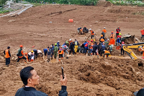 Tim gabungan membantu proses evakuasi korban yang tertimbun material longsor di Cisarua, Minggu (25/1/2026). Foto: Abisatya/kumparan
