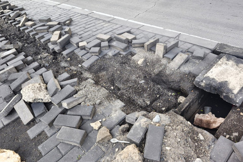 Paving block trotoar terlihat hancur berantakan akibat dugaan aksi pencurian kabel Penerangan Jalan Umum (PJU) di jalan Kramat Jaya, Koja, Jakarta Utara, Minggu (25/1/2026). Foto: Jeni Ritanti/kumparan
