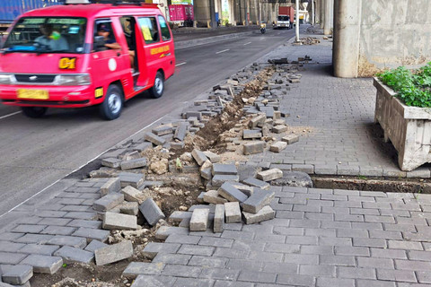 Paving block trotoar terlihat hancur berantakan akibat dugaan aksi pencurian kabel Penerangan Jalan Umum (PJU) di jalan Kramat Jaya, Koja, Jakarta Utara, Minggu (25/1/2026). Foto: Jeni Ritanti/kumparan