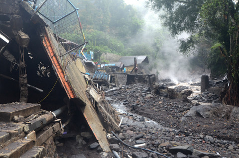 Warga berada samping bangunan yang rusak diterjang banjir bandang di Obyek Wisata Guci, Kabupaten Tegal, Jawa Tengah, Minggu (25/1/2026). Foto: Oky Lukmansyah/ANTARA FOTO