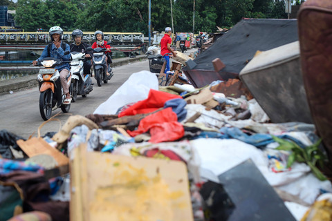 Warga terlihat memadati pinggir Jalan Kembangan Baru, Jakarta Barat, Senin (26/1/2026), untuk melihat tumpukan sampah yang menggunung akibat banjir yang melanda kawasan tersebut beberapa waktu lalu. Foto: Iqbal Firdaus/kumparan
