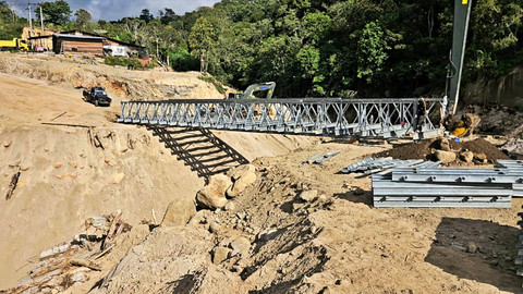 Petugas sedang menggeser rangka yang sudah terpasang ke lokasi jembatan hingga kedua ujungnya bertemu dengan tumpuan di sisi seberang di Jalan Bandara Rembele, Kabupaten Bener Meriah, Selasa (27/1/2026). Foto: Dok. Bakom RI