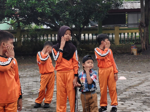 Ariendra Ralea Irgantari (9) membawa adiknya, Reyfan Elcaraka Fahturohman (4), ke sekolah di SD Negeri Gembongan, Kalurahan Salamrejo, Kapanewon Sentolo, Kabupaten Kulon Progo, Rabu (28/1). Foto: Widya Islamiati/kumparan