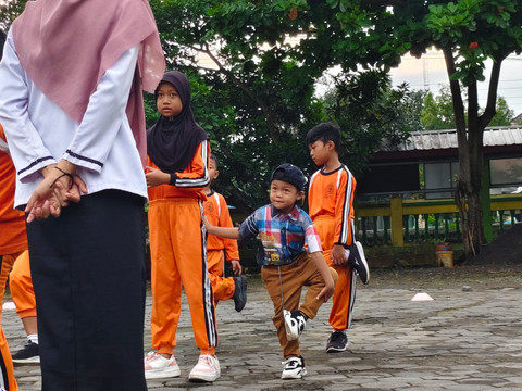 Dikarenakan ibunya sakit, Ariendra Ralea Irgantari (9) harus membawa adiknya, Reyfan Elcaraka Fahturohman (4), ke sekolah di SD Negeri Gembongan, Kalurahan Salamrejo, Kapanewon Sentolo, Kabupaten Kulon Progo, Rabu (28/1). Foto: Widya Islamiati/kumparan