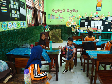 Ariendra Ralea Irgantari (9) membawa adiknya, Reyfan Elcaraka Fahturohman (4), ke sekolah di SD Negeri Gembongan, Kalurahan Salamrejo, Kapanewon Sentolo, Kabupaten Kulon Progo, Rabu (28/1). Foto: Widya Islamiati/kumparan