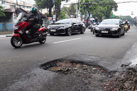 Pengendara melintasi jalan berlubang di Jakarta, Jumat (30/1/2026).  Foto: Jamal Ramadhan/kumparan