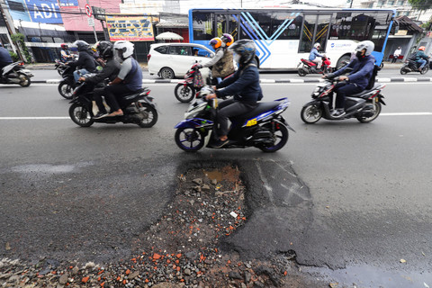 Pengendara melintasi jalan berlubang di Jakarta, Jumat (30/1/2026).  Foto: Jamal Ramadhan/kumparan