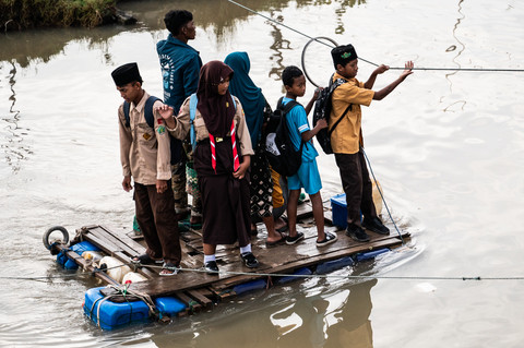 Sejumlah warga menyeberangi Sungai Beringin menggunakan rakit buatan di Mangkang Wetan, Tugu, Semarang, Jawa Tengah, Jumat (30/1/2026). Foto: Aprillio Akbar/ANTARA FOTO