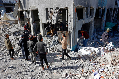 Tim penyelamat dan warga yang menyaksikan kejadian tersebut memeriksa puing-puing kantor polisi Sheikh Radwan di Kota Gaza, setelah serangan udara Israel pada Sabtu (31/1/2026). Foto: OMAR AL-QATTAA/AFP