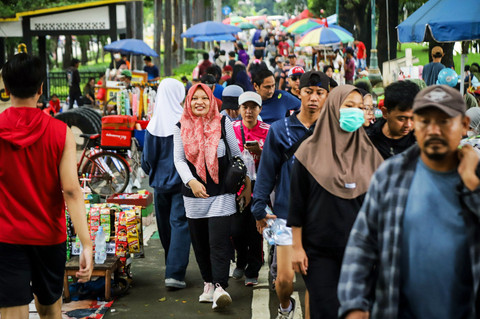 Warga melintasi sejumlah pedagang kaki lima yang menjajakan makanan dan minuman di sepanjang jalur saat kegiatan car free day (CFD) di Kawasan Kanal Banjir Timur (KBT), Duren Sawit, Jakarta Timur, Minggu (1/2/2026). Foto: Iqbal Firdaus/kumparan