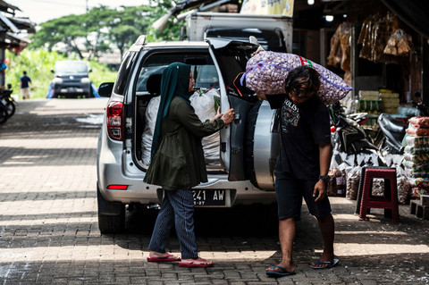 Pedagang (kanan) bersiap memasukan karung bawang putih pesanan pembeli ke dalam mobil di Pasar Induk MAJT-MAS, Semarang, Jawa Tengah, Kamis (5/2/2026). Foto: Aprillio Akbar/ANTARA FOTO