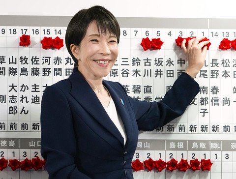 Sanae Takaichi, Perdana Menteri Jepang dan Presiden Partai Demokrat Liberal (LDP) yang berkuasa, memasang lencana yang menandai nama-nama kandidat yang memenangkan pemilihan majelis rendah di markas besar LDP pada hari Minggu, (8/2) di Tokyo. Foto: Keisuke Hosojima/Kyodo News via AP