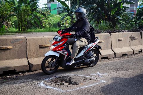Sejumlah kendaraan tampak melambat dan menghindari jalan yang berlubang saat melintas di Jalan H. Naman, kawasan Pondok Kelapa, Jakarta Timur, Rabu (11/2/2026). Foto: Iqbal Firdaus/kumparan
