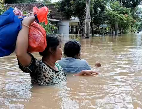 Relawan dengan perahu karet membantu anak-anak korban banjir menuju tempat pengungsian. Foto: kumparan
