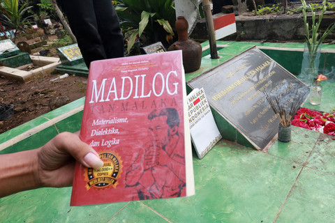 Perwakilan pegiat sejarah meletakkan buku berjudul Madilog yang berisi kumpulan tulisan Tan Malaka di makam pahlawan nasional tersebut di Desa Selopanggung, Kabupaten Kediri, Jawa Timur, Sabtu (14/2/2026). Foto: Prasetia Fauzani/ANTARA FOTO