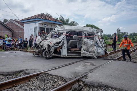 Petugas KAI mengevakuasi bangkai mobil Daihatsu Grand Max yang tertabrak KA Harina relasi Surabaya Pasarturi-Bandung di perlintasan kereta api tanpa palang pintu di Desa Brumbung, Kecamatan Mranggen, Kabupaten Demak, Jawa Tengah, Minggu (15/2/2026). Foto: Aji Styawan/ANTARA FOTO