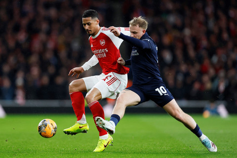 Pemain Arsenal William Saliba berebut bola dengan pemain Wigan Athletic Joseph Taylor pada pertandingan babak keempat Piala FA di Emirates Stadium, London, Inggris, Minggu (15/2/2026). Foto: Peter Cziborra/REUTERS