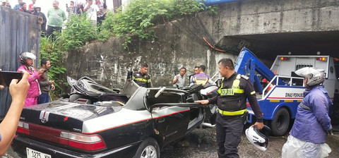 Petugas evakuasi mobil sedan Toyota Corolla "Greco" yang tertimpa truk kontainer. Foto: Dok. kumparan