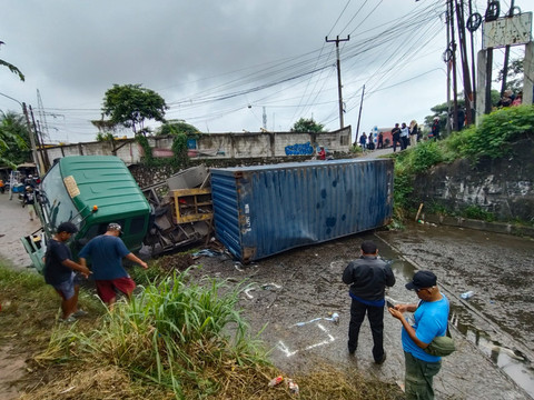Truk kontainer terguling dan menimpa mobil sedan Toyota Corolla "Greco". Foto: Dok. kumparan