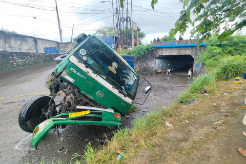 Truk kontainer yang terguling di akses jalan irigasi Desa Kondangjaya, Kecamatan Karawang Timur, Karawang, Senin (16/2/2026). Foto: kumparan