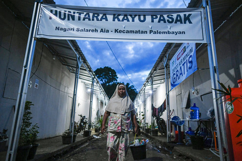 Penyintas bencana banjir Palembayan berjalan di gerbang rumah hunian sementara (huntara) Kayu Pasak, Palembayan, Agam, Sumatera Barat, Rabu (18/2/2026). Foto: Wahdi Septiawan/ANTARA FOTO