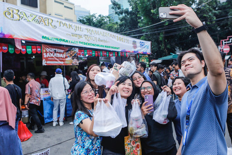 Warga berswafoto usai membeli takjil di Pasar Takjil Ramadhan Bendungan Hilir (Benhil), Jakarta, Kamis (19/2/2026). Foto: Asprilla Dwi Adha/ANTARA FOTO