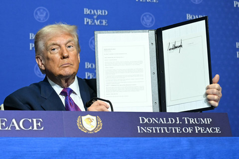 Presiden AS Donald Trump mengangkat dokumen resolusi yang ditandatanganinya selama pertemuan perdana "Dewan Perdamaian" di Institut Perdamaian AS di Washington, DC, pada 19 Februari 2026. Foto: Saul Loeb/AFP