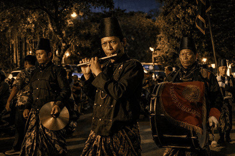 Sejumlah warga mengenakan busana tradisional memainkan alat musik dalam arak-arakan malam hari, menghidupkan suasana kampung dengan irama yang sarat nilai budaya. (Foto: Nawla Rafida/Unsplash)