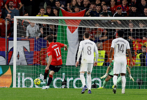 Bendera Palestina berkibar saat Ante Budimir mengeksekusi penalti saat Osasuna vs Real Madrid dalam laga pekan ke-25 Liga Spanyol 2025/26 di Stadion El Sadar, Minggu (22/2) dini hari WIB. Foto: REUTERS/Vincent West