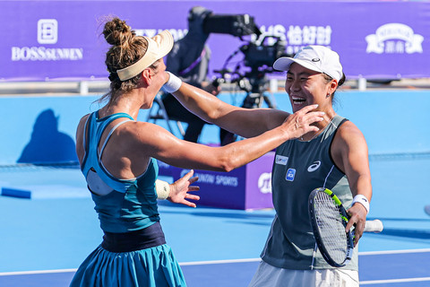 Janice Tjen (kanan) dari Indonesia dan Katarzyna Piter (kiri) dari Polandia merayakan kemenangan mereka melawan Eudice Chong dari Hong Kong dan Liang En-shuo dari Taiwan dalam pertandingan Guangzhou Open di Guangzhou (26/10/2024). Foto: China Out via AFP