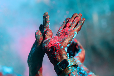 Seorang umat Hindu mengangkat tangan yang berlumur warna saat perayaan keagamaan Holi di Desa Nandgaon, Uttar Pradesh, India, Kamis (26/2). Foto: Adnan Abidi/REUTERS